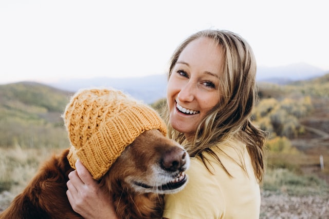 Woman and her dog with a had on